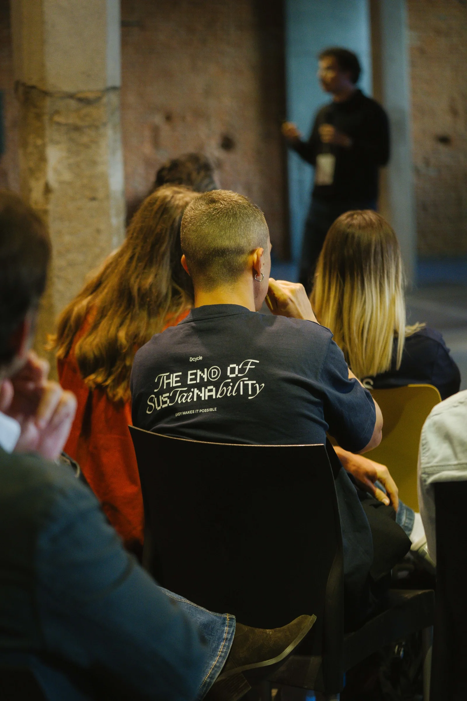 Asistente con camiseta de Dcycle The End of Sustainability viendo el escenario en Ahead Madrid